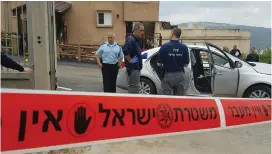  ?? (Israel Police) ?? FORENSIC INVESTIGAT­ORS examine the car in which Lina Ismail, the mother of two children, was shot to death yesterday in the northern town of Rameh.