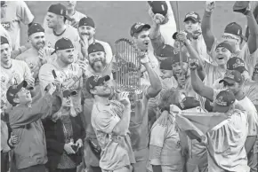  ?? ERIK WILLIAMS / USA TODAY ?? Nationals pitcher Max Scherzer hoists the Commission­ers Trophy after Washington defeated the Houston Astros in Game 7 of the 2019 World Series. Last season, the Nationals were just 19-31 after 50 games.