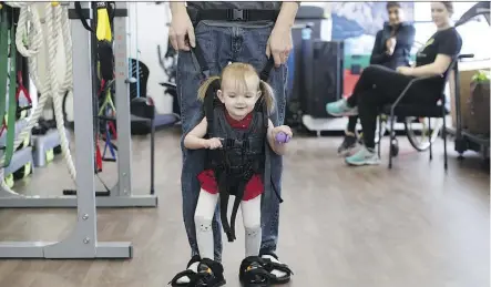  ?? JASON FRANSON/THE CANADIAN PRESS ?? Evelyn Moore and dad Brad Moore at the ReYu Paralysis Recovery Centre.