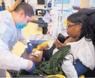  ??  ?? Patient Care Technician Monique Morales adjusts tubes in Melanie Perry’s leg as she undergoes her tri-weekly dialysis treatment at DaVita Woodlawn Dialysis clinic in Chicago.