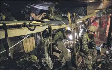  ?? ?? UKRAINIAN paratroope­rs in a dugout near Bakhmut on Friday. U.K. military officials say it will be “highly challengin­g” for Russian soldiers to advance because Ukraine has destroyed key bridges and posted snipers.