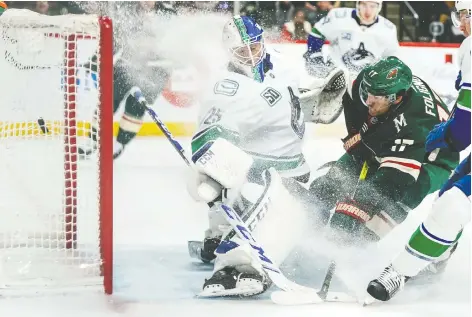  ?? BRaCE HEMMELGARN/USA TODAY SPORTS ?? Minnesota Wild forward Marcus Foligno scores on Vancouver Canucks goalie Jacob Markstrom, but it was the Canucks who scored the 4-1 victory Sunday at Xcel Energy Center in St. Paul, Minn., to halt a short losing streak that had some fans concerned.