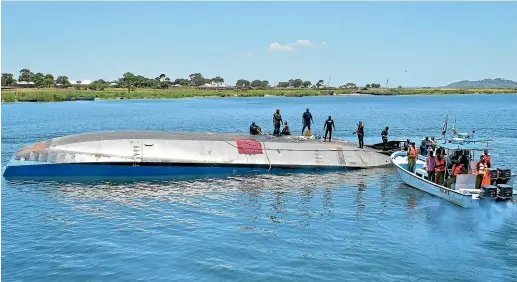  ?? AP ?? Rescue divers stand on top of the capsized MV Nyerere passenger ferry on Ukara Island. The death toll soared past 200 while officials said a survivor was found inside the capsized ferry and search efforts were ending to focus on identifyin­g bodies.