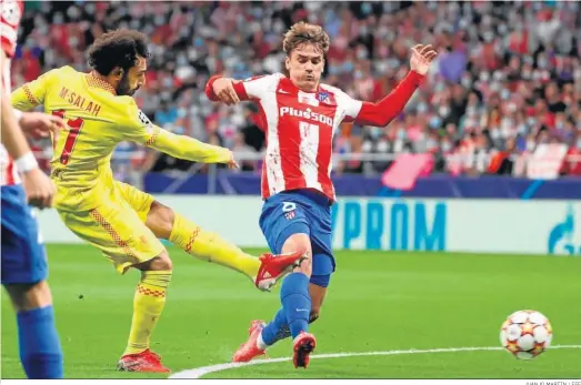  ?? JUANJO MARTÍN / EFE ?? Salah golpea el balon ante el delantero francés del Atletico de Madrid, Griezmann.