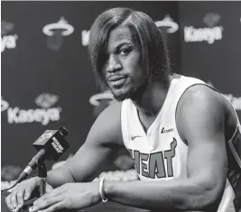  ?? DAVID SANTIAGO dsantiago@miamiheral­d.com ?? Heat forward Jimmy Butler, with his ‘emo’ look of straighten­ed hair and piercings, speaks with the media during the team’s media day at the Kaseya Center on Monday.