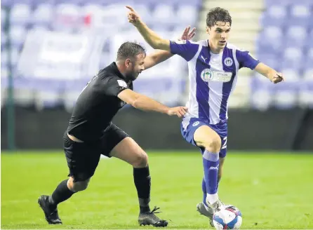  ?? All pictures by PA Photo. ?? COME HERE: Tom Pope tries to get tp grips with Wigan’s Alex Perry at the DW Stadium last night.