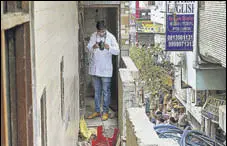  ?? PTI ?? A forensic expert inspects the house where the bodies were found found hanging from an iron grill.