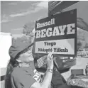  ??  ?? Moz Begay hangs a sign for Navajo Nation presidenti­al candidate Russell Begaye Tuesday.