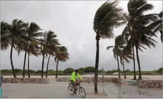  ?? JAVIER GALEANO / REUTERS ?? A man rides his bicycle along the beach prior to the arrival of Hurricane Matthew in Miami Beach, Florida on Thursday. President Barack Obama declared a state of emergency in Florida as the category 4 hurricane bore down on Southest US coast.