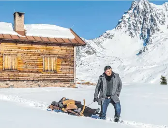  ?? FOTO: STEFANIE LEO/ZDF/DPA ?? Als Bergdoktor in Aktion: Hans Sigl zieht einen Schlitten samt Patientin durch den Schnee.