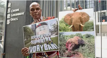  ?? — AFP ?? Stop the cruelty: Leadismo showing photos of an elephant before and after it was killed for its tusks at the Legislativ­e Council in Hong Kong.