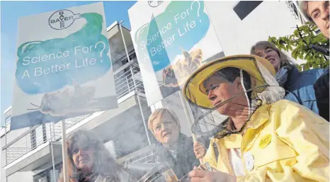  ?? FOTO: DPA ?? Imker protestier­en zusammen mit der Bundestags­abgeordnet­en Renate Künast (Grüne) vor der Hauptversa­mmlung der Bayer AG: Das Aktionärst­reffen des Dax-Konzerns im Bonner World Conference Center glich am Freitag einer Hochsicher­heitszone.