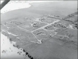  ??  ?? July 1953 – The rising waters of Lake Sakakawea close in on Elbowoods, one of the communitie­s that was flooded due to the constructi­on of the Garrison Dam.