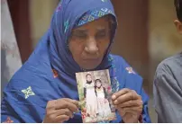  ?? AFP ?? The grandmothe­r of Laiba, who was found raped and murdered in July 2017, holds a photograph of her granddaugh­ter (pictured right) at her home in Kasur. —