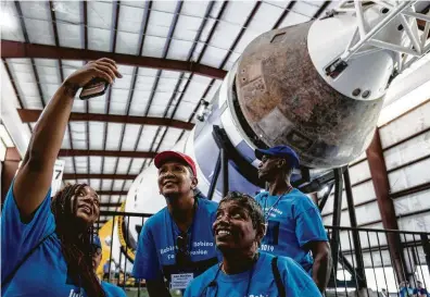  ?? Photos by Brett Coomer / Staff photograph­er ?? Fallon Vallair, from left, of Houston, Ann Minkins and Judith Johnson, both of Beaumont, take a photo in front of the Saturn V rocket during the 50th anniversar­y celebratio­n of the Apollo 11 moon landing at Space Center Houston.