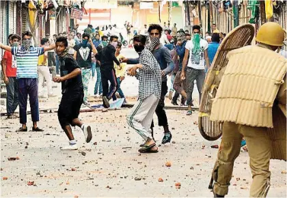  ??  ?? A file image of stone- pelters in Kashmir targeting CRPF personnel