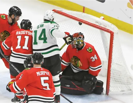  ?? MATT MARTON/AP ?? Stars left wing Jamie Benn scores the go-ahead goal against goalie Petr Mrazek and a quartet of Blackhawks in the third period Thursday night.