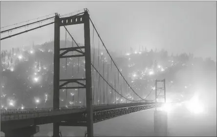  ?? ASSOCIATED PRESS ?? IN THIS IMAGE TAKEN WITH A SLOW SHUTTER SPEED, embers light up a hillside behind the Bidwell Bar Bridge as the Bear Fire burns Wednesday in Oroville, Calif.. The blaze, part of the lightning-sparked North Complex, expanded at a critical rate of spread as winds buffeted the region.