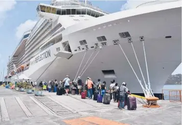  ?? ORVIL SAMUEL/AP ?? To the rescue: British, Canadian and U.S. nationals line up alongside the Royal Caribbean cruise ship Reflection to be evacuated free of charge on Friday from Kingstown on the eastern Caribbean island of St. Vincent. La Soufriere volcano shot out another explosive burst of gas and ash Friday morning as the cruise ship arrived.