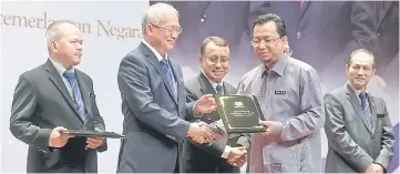  ??  ?? Riot (second left) presents Excellence Service Award (APC) to Abdul Halim Abdul Rahman at the presentati­on of APC 2017 awards ceremony. Also present at the event are Ismail (centre) and Mohd Gazali (left). — Bernama photo