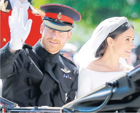  ??  ?? WAVES OF HAPPINESS: Britain’s Prince Harry, Duke of Sussex and his wife Meghan, Duchess of Sussex wave from the Ascot Landau Carriage during their procession on the Long Walk as they head back towards Windsor Castle yesterday after their wedding...