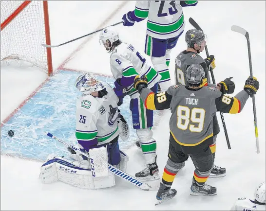  ?? Jason Franson The Associated Press ?? Reilly Smith (19) and Alex Tuch celebrate a goal in front of Canucks goalie Jacob Markstrom. The Knights won 5-0 in the opener of their best-of-seven series.