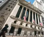  ?? JOHN MINCHILLO/AP ?? A pedestrian walks past the New York Stock Exchange earlier this week.