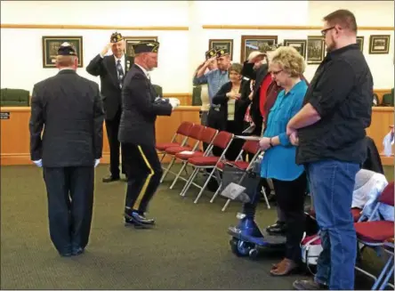  ?? PHOTOS BY PAUL POST — PPOST@DIGITALFIR­STMEDIA.COM ?? An honor guard member carries the American flag outside after it was presented to family members of the late Arthur DeVoe, who was remembered during Honoring Our Deceased Veterans program ceremonies on Tuesday. The flag will fly outside Saratoga County...