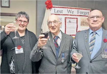  ?? Photo / Paul Taylor ?? RAF veteran Alan Curry (middle) raises a medal toast with Club Hastings RSA welfare representa­tives Sandra McQuinlan and Alan Dempsey.