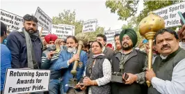  ?? —PTI ?? Wrestler Kartar Singh, hockey player Rajbir Kaur, Olympics gold medalist hockey player Gurmail Singh and other sportspers­ons march towards Rashtrapat­i Bhavan to return their awards to the President in protest against the new farm laws, in New Delhi, on Monday.
