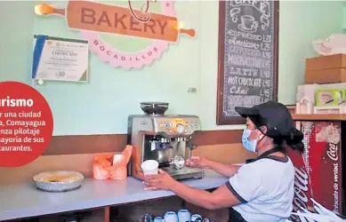  ??  ?? PREVENCIÓN. Empleada de una cafetería usa mascarilla para preparar café en una máquina de espresso.