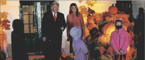  ?? ASSOCIATED PRESS ?? PRESIDENT DONALD TRUMP AND FIRST LADY MELANIA TRUMP greet trick-or-treaters on the South Lawn during a Halloween celebratio­n at the White House, Sunday, in Washington.