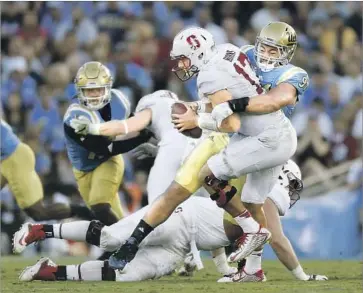  ?? Gina Ferazzi Los Angeles Times ?? UCLA DEFENSIVE LINEMAN Jacob Tuioti-Mariner sacks Stanford quarterbac­k Ryan Burns.