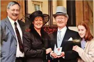  ?? ?? ●●David McCarthy with his children, Ian and Jane and granddaugh­ter Dorothy at Buckingham Palace in 2001 after receiving his MBE