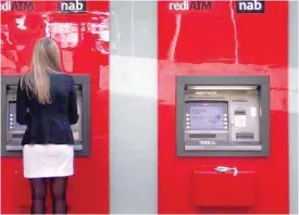  ??  ?? A woman uses a National Australia Bank ATM in Sydney. — Reuters