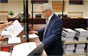  ?? Bryan Terry/The Oklahoman via AP ?? ■ Attorney Don Knight hands over documents inside the Oklahoma Court of Criminal Appeals office Friday in Oklahoma City as he files for a new hearing for his client, death row inmate Richard Glossip. The Oklahoma Court of Criminal Appeals on Friday set execution dates for six death row inmates, just hours before Glossip’s attorney planned to ask for a rehearing in his case. Glossip, whose first conviction and death sentence was overturned, was hours from being executed in September 2015 following a second conviction and death sentence when prison officials realized they had received the wrong lethal drug. His execution is scheduled for Sept. 22.