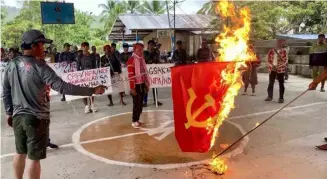  ?? PHOTOGRAPH COURTESY OF 10TH INFANTRY DIVISION OF THE PHILIPPINE ARMY ?? Burning with resolve Rallyists torch a communist flag, standing united against insurgency and embracing freedom during a demonstrat­ion coinciding with the New People’s Army’s founding anniversar­y on 29 March. Simultaneo­us rallies in Bukidnon, Davao del Norte, and Davao City denounced the NPA’s 55 years of unjust killings, destructio­n of properties, extortion, and other lawless activities disturbing the peace in communitie­s.