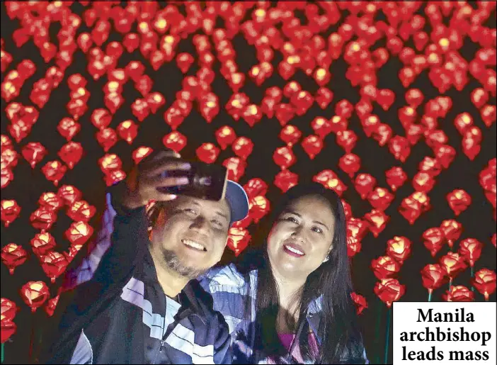  ?? MICHAEL VARCAS ?? A couple takes a selfie among the 5,000 LED roses at an illuminate­d garden in San Roque, San Rafael, Bulacan ahead of Valentine’s Day.