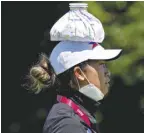 ?? AP/MATT YORK ?? BIANCA PAGDANGANA­N wears an ice pack on her head to keep cool during a practice round prior to the women’s golf event at the 2020 Summer Olympics, Tuesday, August 3, 2021, at the Kasumigase­ki Country Club in Kawagoe, Japan.