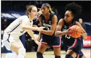  ?? (AP/Gary Landers) ?? Connecticu­t guard Christyn Williams (right) drives to the basket Saturday against Xavier center Megan Harkey during the topranked Huskies’ 83-32 victory in Cincinnati. The former Central Arkansas Christian standout scored 22 points as the Huskies won their eighth consecutiv­e game.