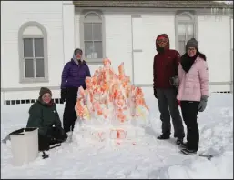  ?? Photo by RB Smith ?? BONFIRE— Elsa Hobbs, Kayla Ackerman, Timothy Davies and Sarah Swann pose in from of their snow sculpture - a snow-bonfire - at the Snow Sculpture Contest on Saturday.
