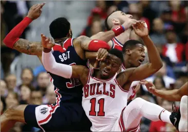  ?? Alex Brandon / AP ?? Washington forward Mike Scott (left), Chicago guard David Nwaba (11), Washington center Marcin Gortat and Chicago guard Kris Dunn get tangled up as they go for a rebound in Sunday’s game in Washington.