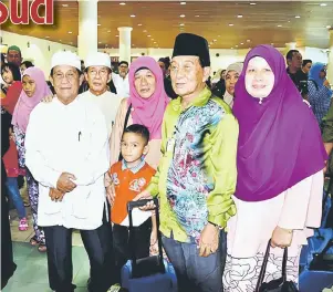  ??  ?? KENANGAN: Abang Suhaili (dua kanan) dan ahli keluarga lain merakam gambar kenangan bersama anaknya Dayang Zahora (tiga kanan) yang akan mengerjaka­n ibadah haji tahun ini.