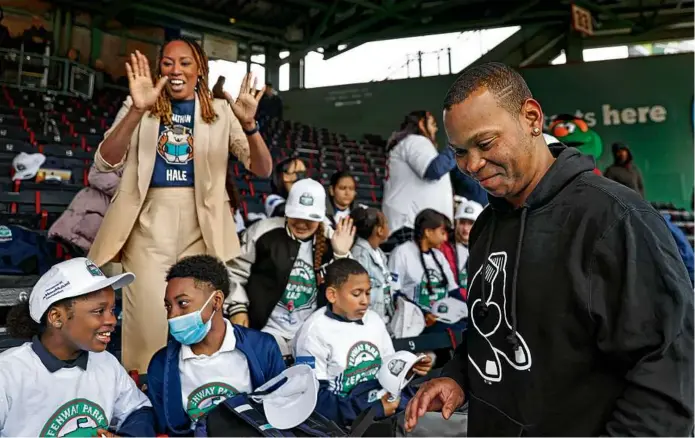  ?? DAVID L. RYAN/GLOBE STAFF ?? Red Sox third baseman Rafael Devers (far right) made a quick visit with students during their time at Fenway Park. Student Hilana Dembo (below) checked out a pair of baseball binoculars while seated at Fenway Park.