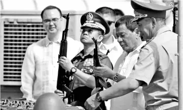  ?? — AFP photo ?? Duterte (second right) and Armed Forces of the Philippine­s (AFP) chief Eduardo Ano (second left) inspect Kalashniko­v rifles with Shoigu (right) during the handover ceremony at the Port of Manila.