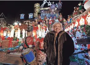  ?? ASSOCIATED PRESS ?? Brooklyn, N.Y., resident Lucy Spata poses in front of her house, which she decorates each holiday season with elaborate Christmas decoration­s that draw thousands of onlookers.