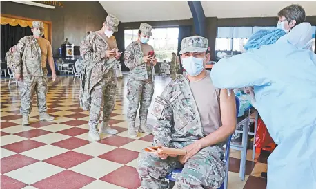  ??  ?? Un miembro de la fuerza aérea es vacunado con la primera dosis de Pfizer en una base de Lima, Perú.