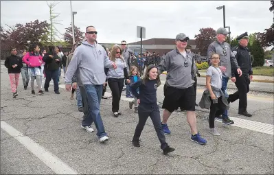  ?? Photos by Ernest A. Brown ?? Woonsocket Police Chief Thomas Oates, far right, joins officers and their family members in Woonsocket Tuesday morning for the first leg of the annual COPSWalk to Washington, D.C.