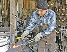  ??  ?? Jeb Stewart of Yuba City hammers a rusted old railroad nail into a tomahawk at the blacksmith shop at Gold Trader Flat in 2015.