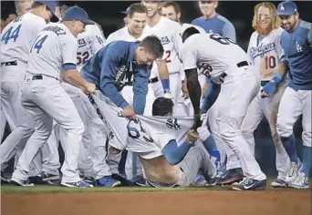  ?? Kevork Djansezian Getty Images ?? KYLE FARMER has his jersey ripped by teammates celebratin­g his game-winning double in the 11th inning against the San Francisco Giants on July 30. It was Farmer’s first major league at-bat.